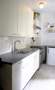 阿姆斯特丹Ground Floor Apartment Westerpark的厨房配有白色橱柜和水槽