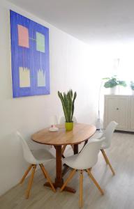 阿姆斯特丹Ground Floor Apartment Westerpark的一张带白色椅子的木桌,上面有植物