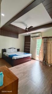 海得拉巴Hitech Shilparamam Guest House的一间卧室设有一张床和一个大窗户