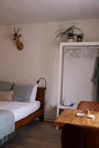 马尔德海姆House Rhodopi的卧室配有一张床和一张桌子,墙上挂着鹿头
