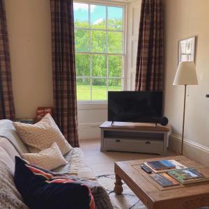 莫珀斯Meldon Cottage in Morpeth, Northumberland的带沙发和电视的客厅