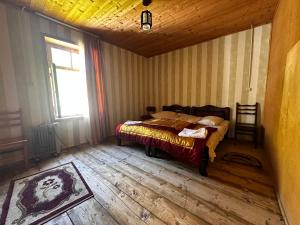 乌树故里安吉丽娜旅馆的一间卧室配有一张铺有木地板的床和窗户。