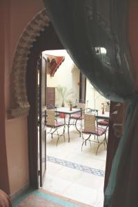 拉巴特达尔阿依达酒店的通往带桌椅的天井的开放式门廊