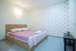 巴特沃思Peace Casa - Homely & Cosy的一间卧室配有一张带紫色毯子的床