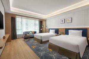 广州voco Guangzhou Shifu, an IHG Hotel的酒店客房设有两张床和电视。