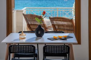 利加里亚Beachfront Orange apt-Ligaria Beach的阳台上的桌子上摆放着花瓶