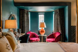 哈瑟西奇The George的一间卧室配有一张床和两张粉红色的椅子