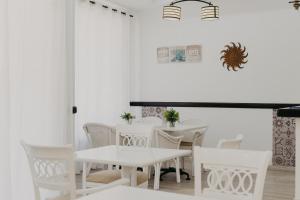 EsteponaMare Estepona Hotel的白色的用餐室配有白色的椅子和桌子