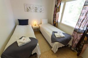 罗瓦涅米Nord Riverside的带窗户的客房内设有两张单人床。