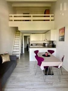 圣马迪拉莫Appartement Duplex Climatisé Le Trident的一间带桌椅的客厅和一间厨房