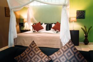 OtaviGabus Safari Lodge的一间卧室配有一张带天蓬的床