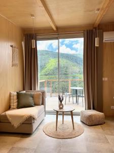 曼泰加什Casa Raposa Lodges - Terrace Mountain View的客厅配有沙发和窗户前的桌子
