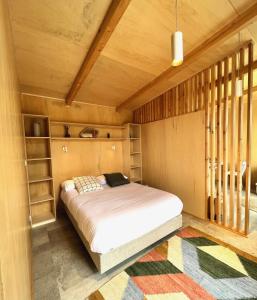 曼泰加什Casa Raposa Lodges - Terrace Mountain View的木制客房内的一间卧室,配有一张床