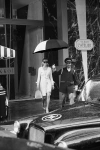 伊斯坦布尔Vakko Hotel and Residence的男人和女人在街上用雨伞行走