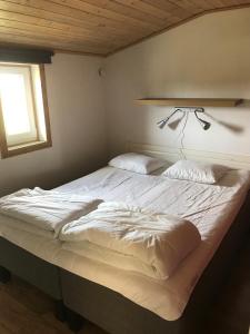 雪平斯维克Svalsjöns Stugor Öland的卧室内的一张大白色床,带有窗户
