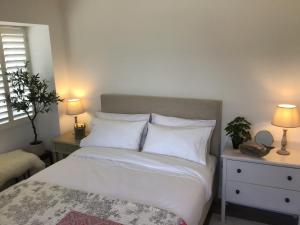普里茅斯Griffin的一间卧室配有带白色床单和枕头的床。