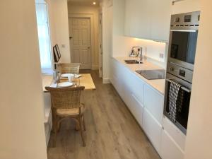 普里茅斯Griffin的厨房配有白色橱柜和桌椅