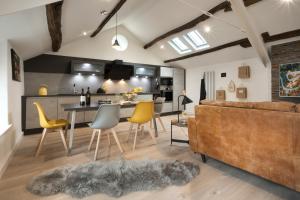 卡特梅尔Wharton House Mews in Cartmel, Lake District的客厅以及带沙发和桌子的厨房。
