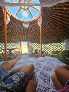 拉梅特拉·德·玛尔Yurta Bora Bora的躺在草屋床上的人