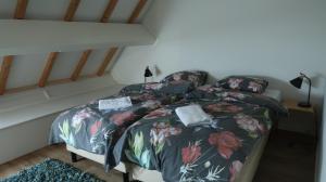 GeersdijkDe Galerie - Landgoed Rijckholt的一间卧室配有一张带花卉床罩的床
