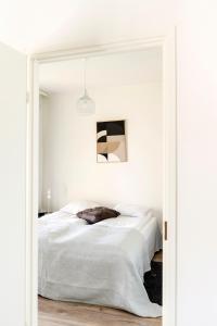 奥卢Kotimaailma Apartments Loimu V的白色卧室配有床和镜子