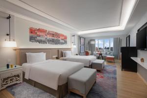 广州voco Guangzhou Shifu, an IHG Hotel的酒店客房带两张床和一个客厅