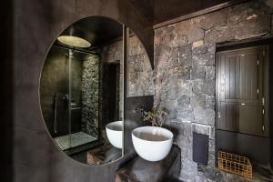 阿克罗蒂里Serra Exclusive Suites的一间带两个盥洗盆和大镜子的浴室