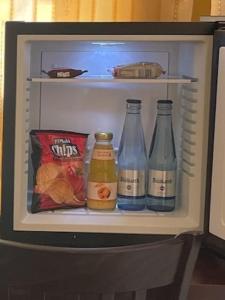 汉堡汉堡市中心城市客栈酒店的冰箱,内含三瓶苏打水和小吃