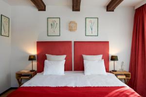 代堡Maison d'hôtes Ermitage的一间卧室配有红色床头板和白色的床