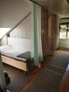 科尔波Guesthouse Siskonpeti的一间卧室配有床、窗帘和地毯