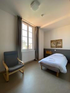 波尔多Hotel Saint Louis Beaulieu - Bordeaux的卧室配有床、椅子和窗户。