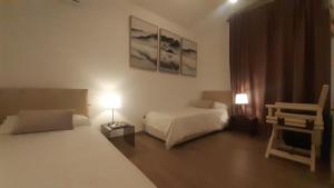 蓬塔阿拉Villa Elisa的一间卧室配有两张床、一把椅子和两盏灯。