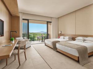 三亚三亚艾迪逊酒店的酒店客房设有两张床、一张桌子和一张桌子。