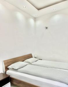 奥拉迪亚SMART GuestHouse的卧室配有白色墙壁的床
