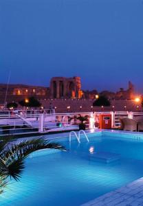 卢克索Movenpick MS Sunray Nile Cruise 4 / 7 Nights Each Thursday From Luxor - 3 Nights Each Monday From Aswan的一个晚上的游泳池,以城市为背景
