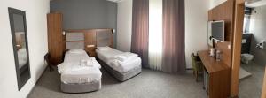 默费尔登-瓦尔多夫Airport Global Hotel, Olive INN的酒店客房设有两张床和电视。