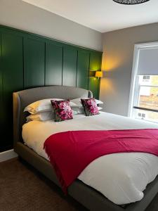 ManningtreeThe Crown Pub and Hotel的一间卧室配有一张大床和绿色床头板
