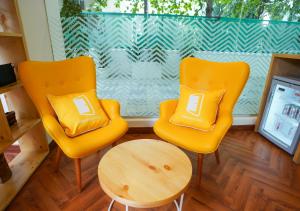 浦那Bloom Hotel Koregaon Park的两把黄色椅子和一张桌子,在窗前