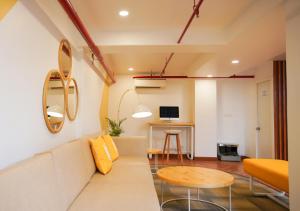 浦那Bloom Hotel Koregaon Park的客厅配有沙发和桌子