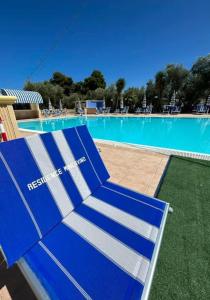 维耶斯泰Appartamenti Vacanze Minervino的游泳池前的蓝色长椅
