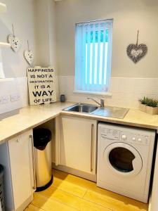 邓迪Castlehill的厨房配有水槽和洗衣机