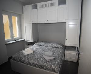 都灵Corte Paradiso的卧室配有白色橱柜和1张带2条毛巾的床