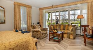 德吕特花卉流庄园酒店的一间卧室配有一张床、一张沙发和椅子