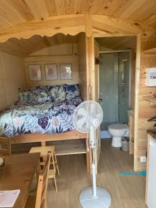 CarentoirLes roulottes de Kuzco的小屋内设有一间带床铺和风扇的卧室