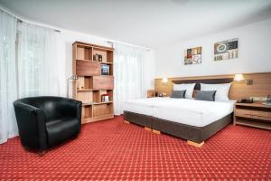 斯图加特阿帕特商务酒店的一间卧室配有一张大床和一张黑椅