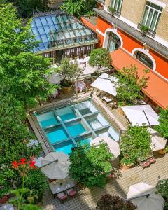 巴黎莱佛士皇家巴黎梦索酒店的享有带桌子和遮阳伞的游泳池的顶部景致