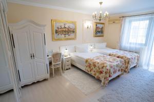 苏恰瓦爱丽丝旅馆的一间卧室配有两张床、一张书桌和一个吊灯。