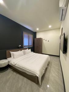 埔里亚士密民宿的卧室配有一张白色大床和电视。
