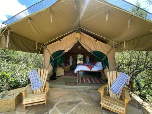 奈瓦沙Echoes of Eden: River Retreat的帐篷配有两把椅子和一张床