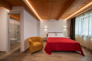 CapestranoAgriRelais San Giovanni的一间卧室配有红色的床和黄色的椅子